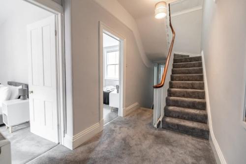 a hallway with a staircase in a house at Spacious Victorian for 10 across Royal Infirmary in Leicester