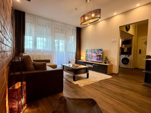 a living room with a couch and a tv at City Edge Hideaway Apartment in Nagykanizsa