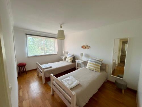 a bedroom with two beds and a window at Caparica Golf & Beach Accomodation in Almada