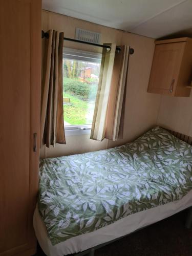 a small bedroom with a bed and a window at Fenlake holiday accommodation in Metheringham