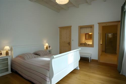 a bedroom with a large white bed in a room at La Campagne in Saint-Hubert