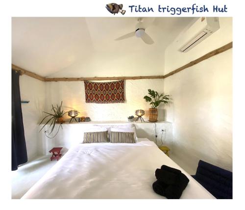 a bedroom with a white bed and a window at Triggerfish Hut at Casa Domingo in Ban Thong Phlu