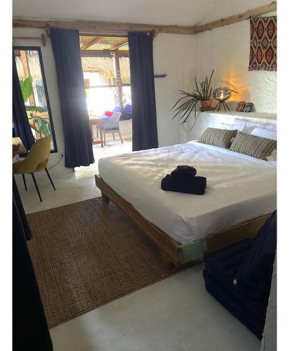 a bedroom with a bed with a black bag on it at Triggerfish Hut at Casa Domingo in Ban Thong Phlu