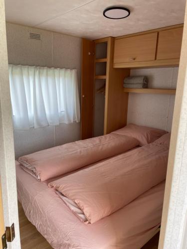 a bedroom with two beds and a window at Houseboatvinkeveen Lelie in Vinkeveen
