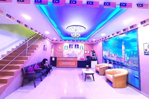 a room with stairs and a person sitting on a couch at Coop Hotel Kangar in Kangar