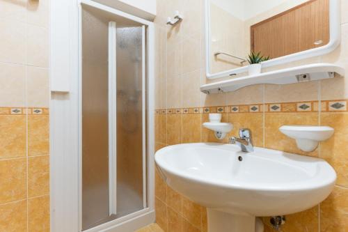 a bathroom with a sink and a shower at Farnie Lido Altanea in Caorle