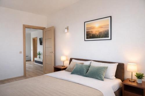 a bedroom with a bed with two lamps on it at Birštono Terasos in Birštonas