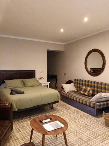 a bedroom with a bed and a couch and a table at Suite Duquesa de Parcent in Ronda