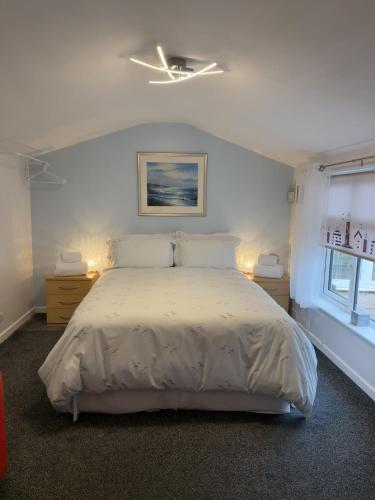 a bedroom with a white bed and a window at The Garden Suite Holt in Holt