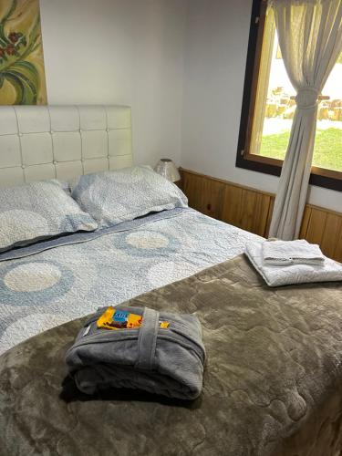 a bed with a backpack sitting on top of it at Eco Chalés Águas Claras in Lumiar