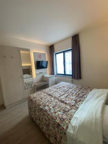 a hotel room with a bed and a television at Hotel Cleo in Kasterlee