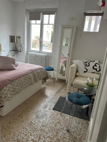 a bedroom with a bed and a chair and a mirror at IDEAL ART DECO TEMPERE, PARKING SECURISE centre Darcy Liberté Gare-vill in Dijon