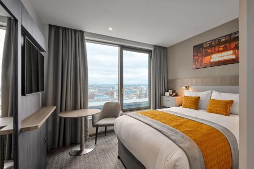 a hotel room with a bed and a large window at Maldron Hotel Glasgow City in Glasgow
