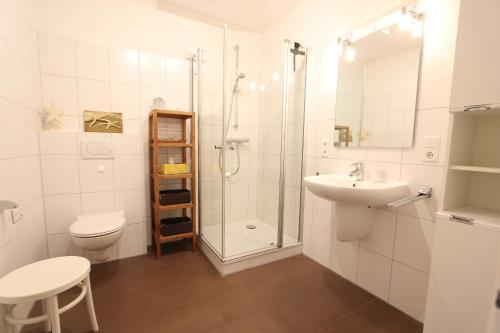 a bathroom with a shower toilet and a sink at MeerGlück in Langeoog