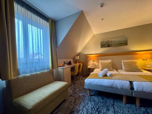 a hotel room with a bed and a window at Logis Hôtel Restaurant & Spa au Soleil in Wettolsheim