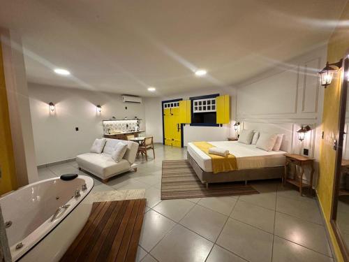 a bedroom with a bed and a tub in a room at Pousada Villa Mariana in Pirenópolis
