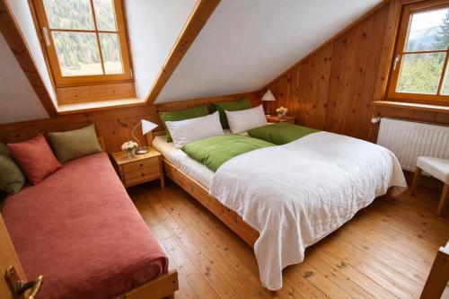 a bedroom with a bed and a bench in a attic at Chalet Steiermark in Pusterwald