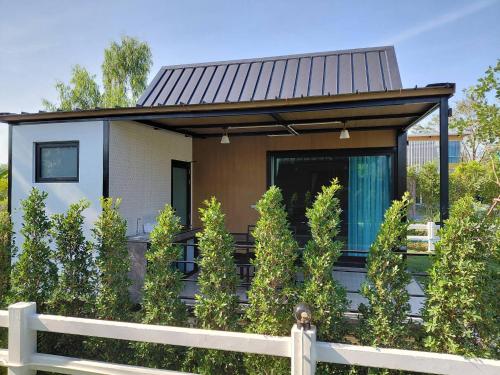 a small house with a fence in front of it at ลึกลับรีสอร์ทบ้านนา in Nakhon Nayok