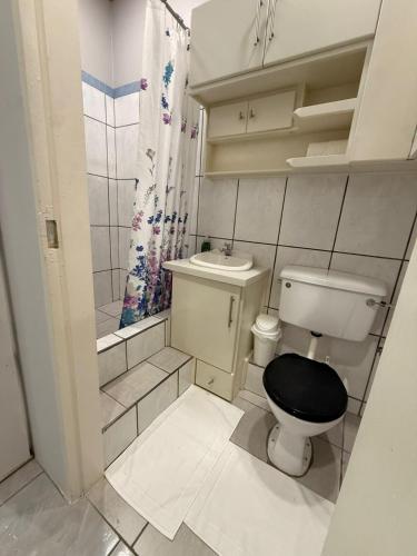 een kleine badkamer met een toilet en een wastafel bij Rest a While in San Juan