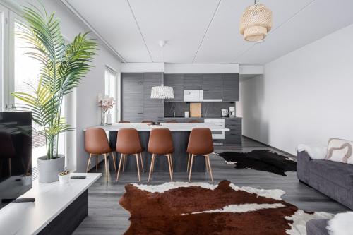 a kitchen and living room with a table and chairs at Luxurious Penthouse - Hot Tub & Sauna in Tampere