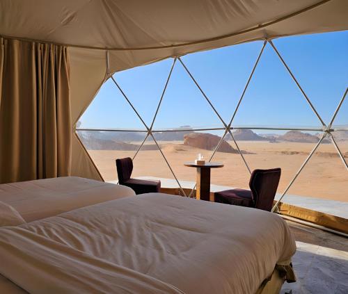 a bedroom with a view of the desert from a tent at ULORA Luxury Camp in Wadi Rum