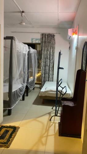 a room with three beds and a couch in a room at Hotel Ruwan in Kataragama