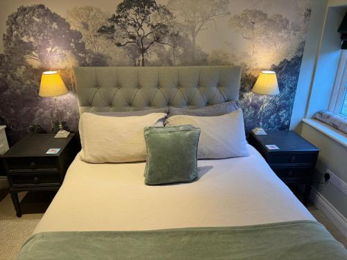 a bedroom with a bed with a green pillow on it at Charming one bedroom cottage in Basingstoke