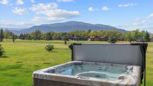 a hot tub in a field with mountains in the background at Paradise View in Red Lodge