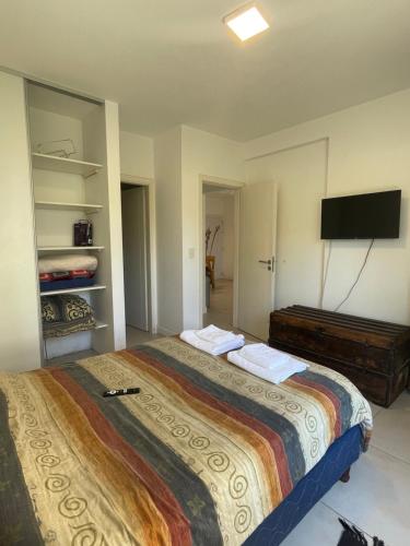 a bedroom with a large bed and a flat screen tv at Vivi Tigre Apart in Tigre