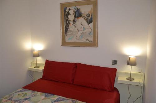 a bedroom with a red bed and two tables with lamps at Casa Tirli in Tirli