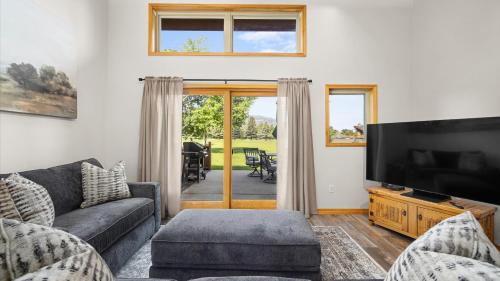 a living room with a couch and a flat screen tv at Peaks & Par in Red Lodge