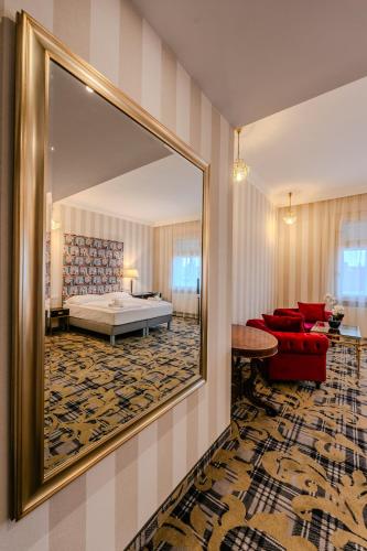 a room with a mirror and a bed and a couch at Pannonia 1893 Prémium in Sopron