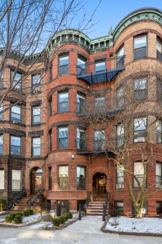 a large brick building with a staircase in front of it at SympleLive Hotel in Boston