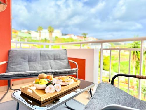 a tray of fruit on a table on a balcony at The Pink Villa - Holidays in Madeira Island in Caniço