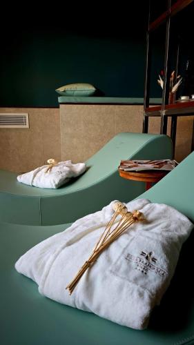 a room with two beds with a blanket and wooden sticks at Villa Francesca Relais & private Spa in Gradara