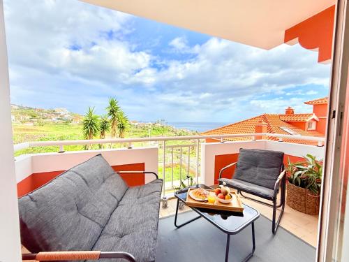 a balcony with two chairs and a table with a view at The Pink Villa - Holidays in Madeira Island in Caniço