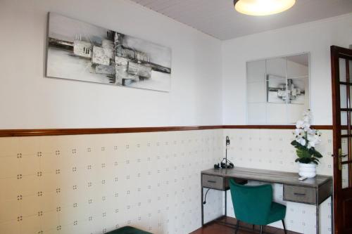 a room with a desk and a green chair at Paraíso Verde in Algarvia