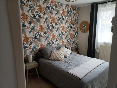 une chambre avec un lit recouvert de papier peint à fleurs dans l'établissement MG72, à Moncé-en-Belin