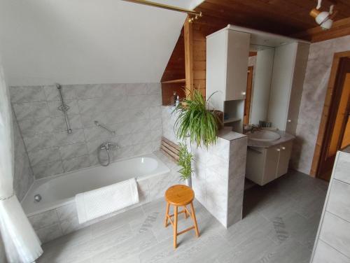 a bathroom with a tub and a sink and a stool at Land - Haus in Pusterwald