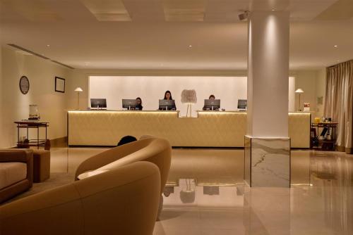 a lobby with a waiting room with people sitting in computers at The May Fair, A Radisson Collection Hotel, Mayfair London in London