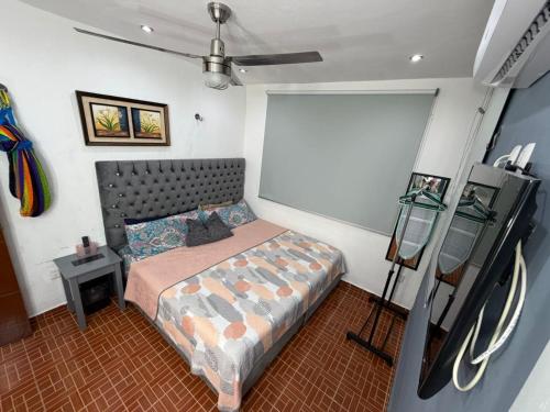 a small bedroom with a bed and a tripod at Casa Santa Cruz in Chetumal