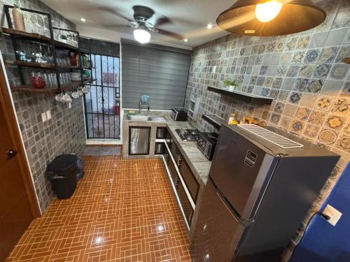 a kitchen with a refrigerator and a stove top oven at Casa Santa Cruz in Chetumal