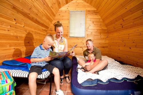 a group of people sitting in a room with a baby at Woodland Camping Pod in Hale