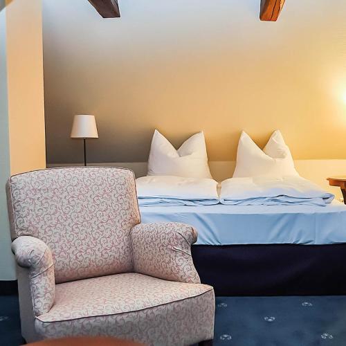 a bedroom with a bed with a chair next to it at Burg Warberg in Warberg