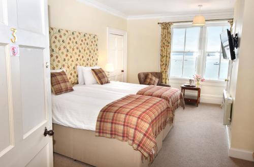 Habitación de hotel con cama y ventana en The Royal Hotel Cromarty en Cromarty