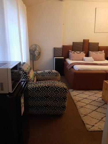 a bedroom with a bed and a chair and a couch at Portia inn accommodation in Pretoria