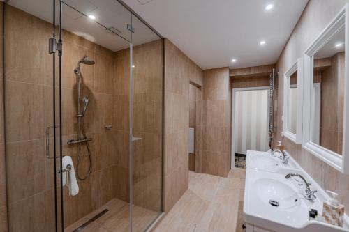 a bathroom with a glass shower and a sink at Pannonia 1893 Prémium in Sopron