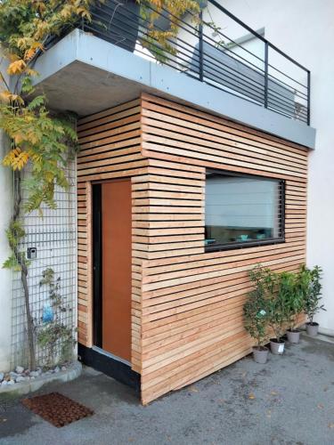 un edificio in legno con una porta e un balcone di Scandic tiny a Saint-Julien-en-Genevois