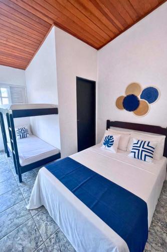 a bedroom with a blue and white bed and a couch at Nalu Suítes Maresias in Maresias
