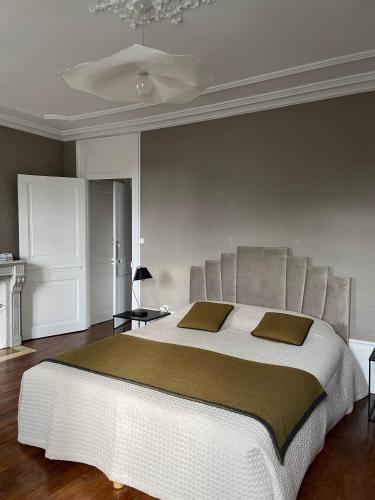 La Chambre d'Adèle في لوهانس: غرفة نوم بها سرير أبيض كبير مع وسادتين